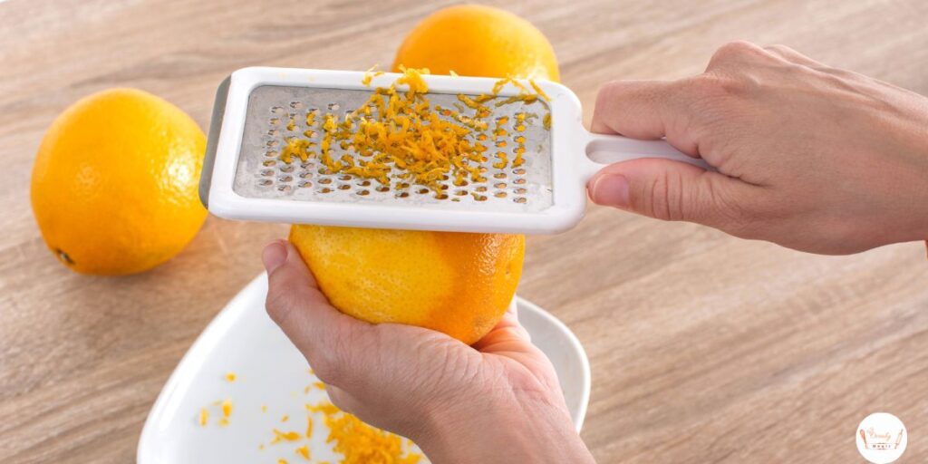 Fresh orange zest being grated to add citrus flavor to moist gluten-free pumpkin bread recipe.