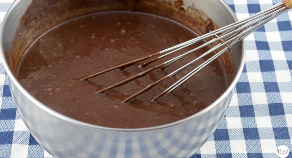 Mixing glossy brownie batter in a bowl.