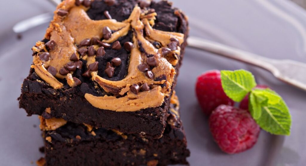 Fudgy peanut butter brownies sliced and stacked on a plate.