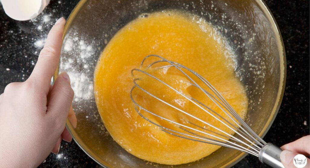 Whisking eggs and sugar until frothy for brownie mix