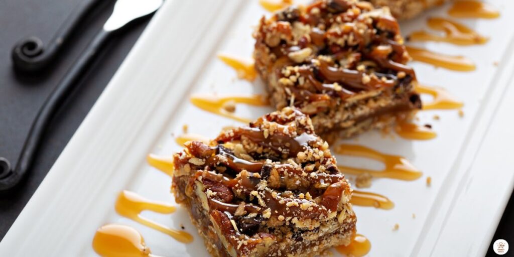 Caramel apple cheesecake bars cut into squares, drizzled with caramel sauce and garnished with fresh apple slices."