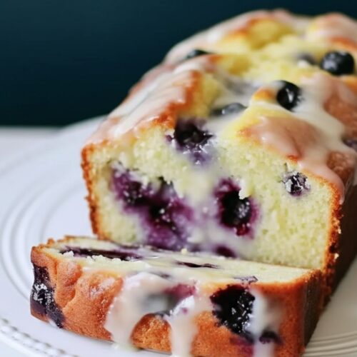 Lemon glaze poured over lemon blueberry bread loaf