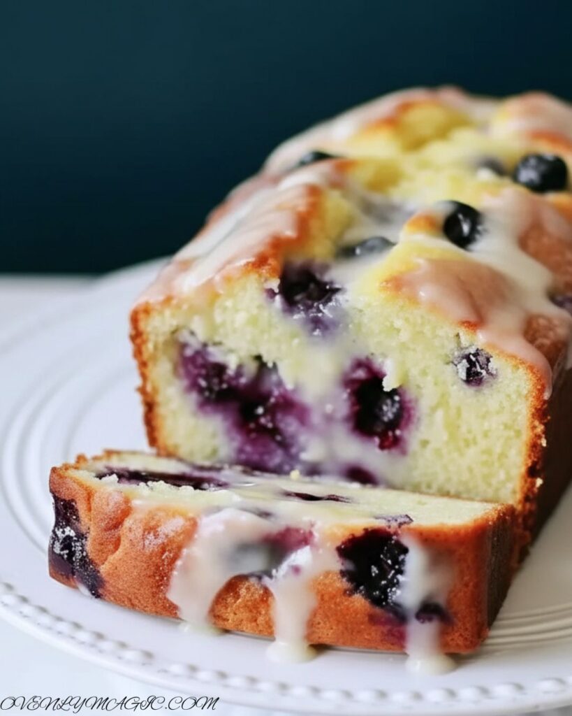 Lemon glaze poured over lemon blueberry bread loaf