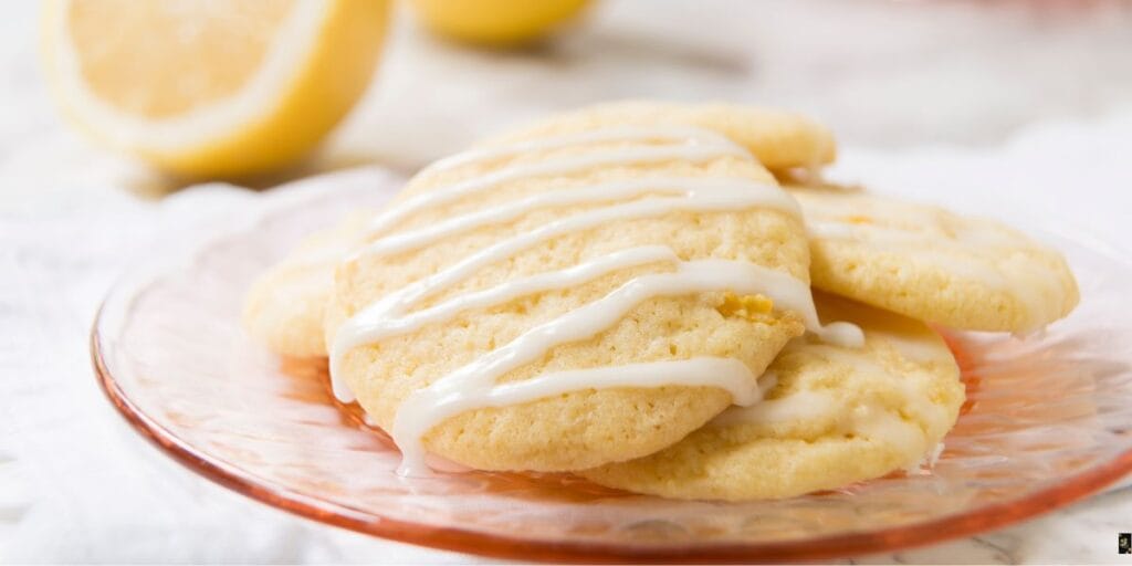 Freshly baked lemon cake mix cookies arranged on a white plate, showcasing their soft texture and golden edges.