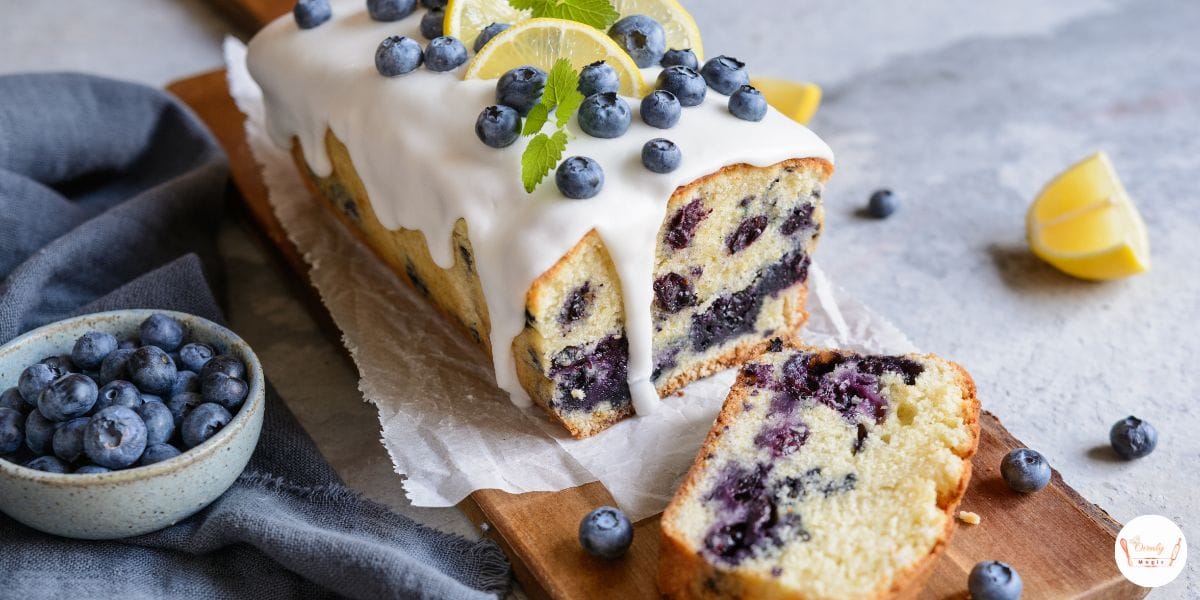 Freshly baked lemon blueberry bread loaf on a white plate