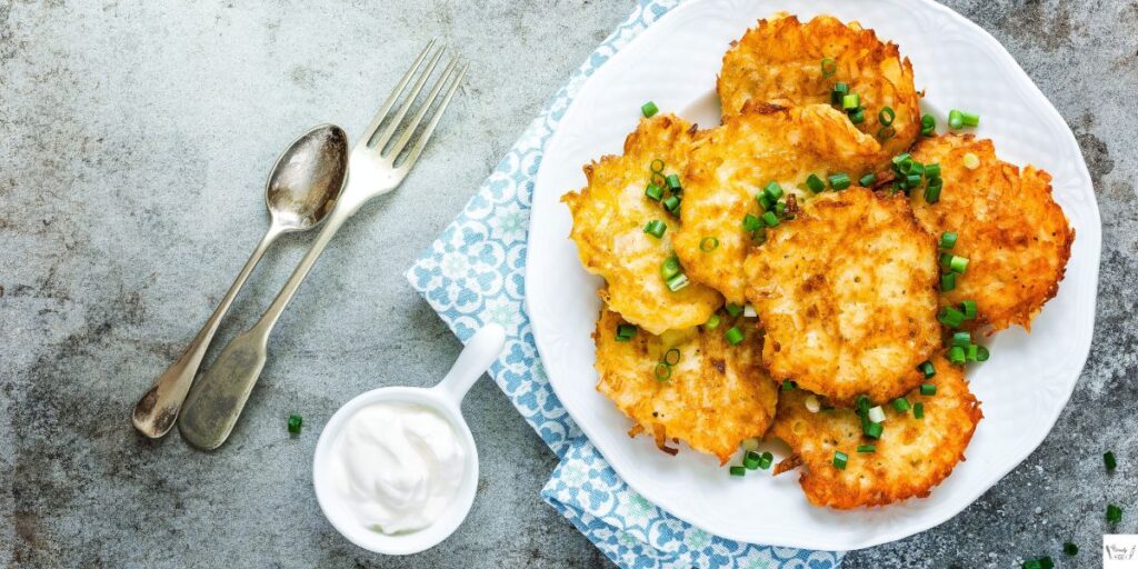 Crispy golden Perkins-style potato pancakes served with applesauce and sour cream on a white plate.