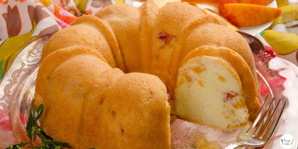 A slice of peach cobbler pound cake showing soft texture and juicy peach chunks.