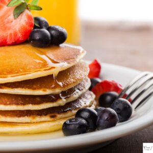 Stack of fluffy Perkins pancakes with butter and syrup on top