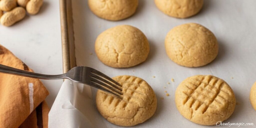 Shaping peanut butter cookies with fork before baking