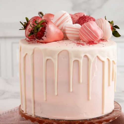 Soft and moist Champagne Cake with pink champagne buttercream frosting on a cake stand