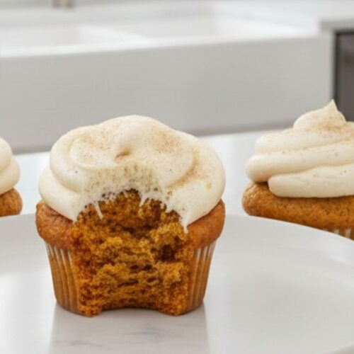 Plated pumpkin spice cupcakes with cream cheese frosting ready to serve for cozy fall gatherings