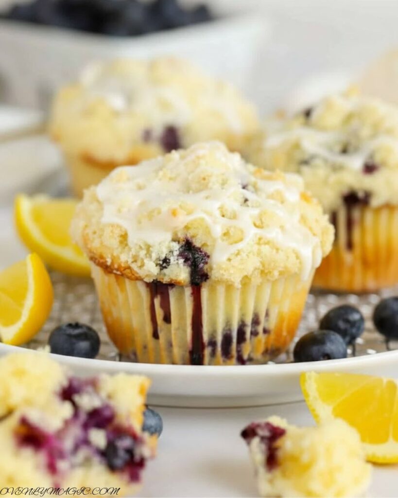Freshly baked lemon blueberry muffins with golden domes and juicy blueberries