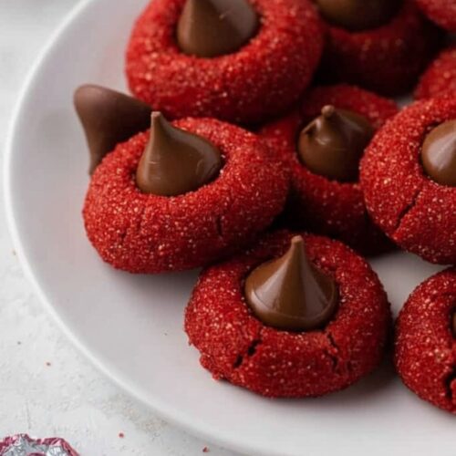 Stack of soft Hershey’s Red Velvet Blossoms Cookies topped with Hershey’s chocolate kisses on a wire cooling rack, rustic table, cozy and inviting presentation”