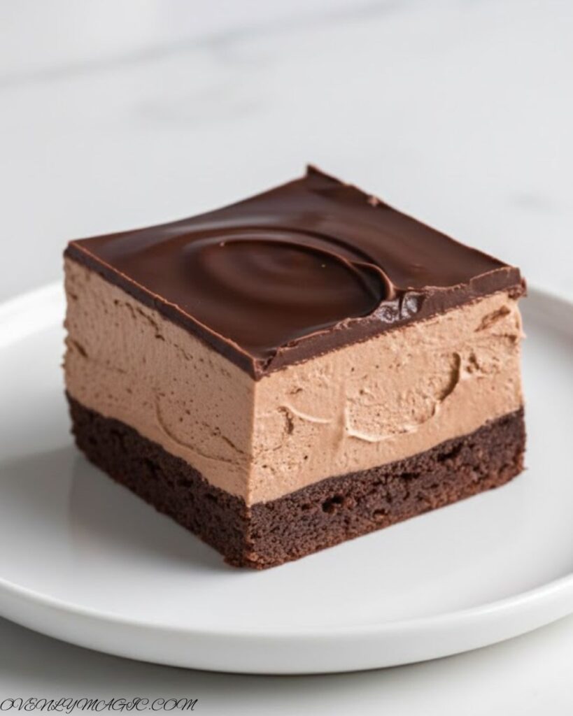 Cross-section showing brownie, chocolate mousse, and ganache layers in a chocolate mousse brownie