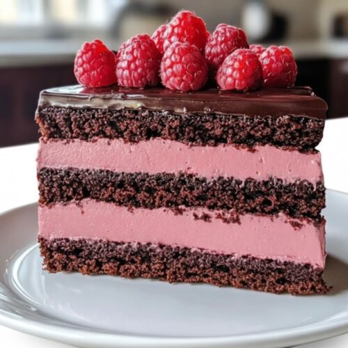 Dark Chocolate Raspberry Mousse Cake with glossy ganache and fresh raspberries on top