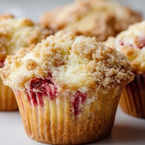Freshly baked strawberry cream cheese muffins on a cooling rack – soft, golden muffins with a creamy center and fresh strawberry chunks.