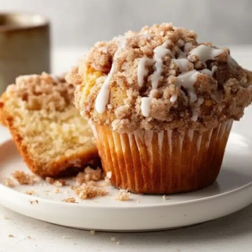 Muffins on a plate with a cup of coffee, napkin, or breakfast table setup — cozy vibe.