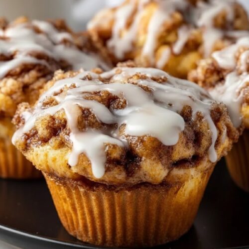 Muffins on a plate with coffee or tea, napkin, and fork — cozy breakfast/brunch vibe.