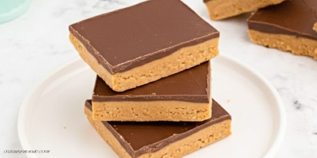 No-Bake Peanut Butter Bars topped with chocolate, sliced into squares on a parchment-lined tray