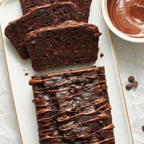 Sliced Double Chocolate Banana Bread with gooey chocolate chips, moist banana texture, and rich chocolate swirls, served on a rustic plate.
