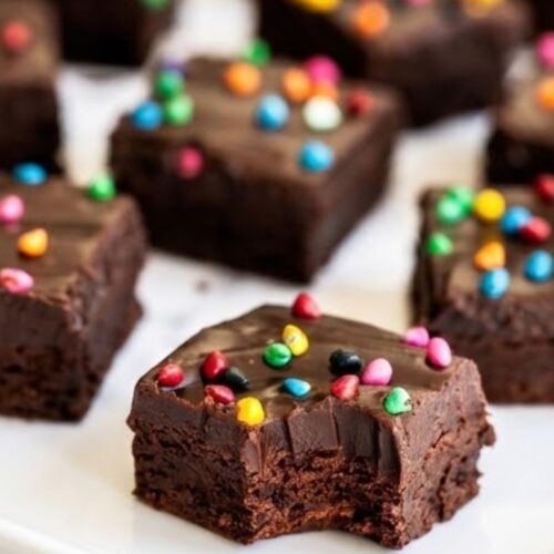 Homemade cosmic brownies cut into squares with colorful candy topping